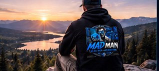 Person overlooking a lake at sunset in a Mad Man hoodie